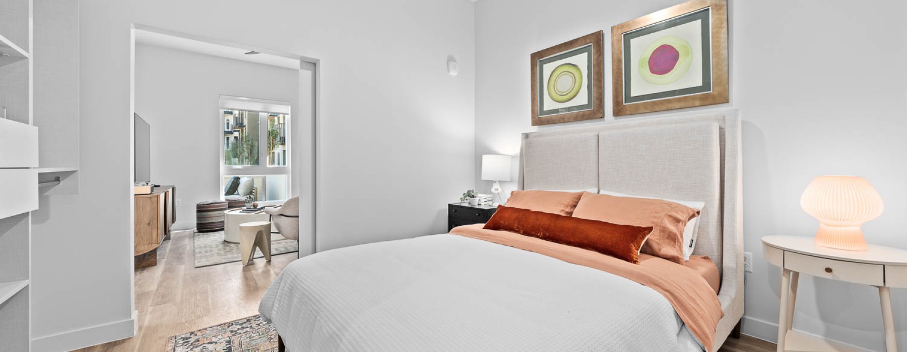 Model bedroom at The Monde Apartments in Scottsdale, AZ, featuring wood grain floor paneling and modern decor.